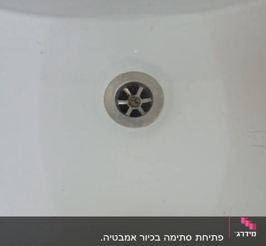 כיור חרס לבן עם מים עומדים ופתחי ניקוז